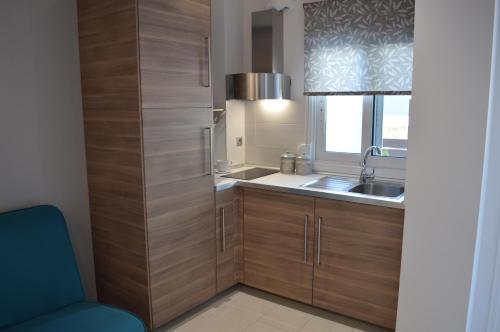 kuchnia z drewnianymi szafkami i zlewem w obiekcie Aqua Luxury Villas w mieście Nea Potidaea
