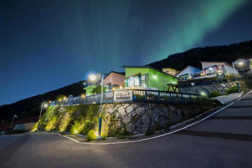 an image of a house with the northern lights in the sky at 13 Ohoo in Namhae