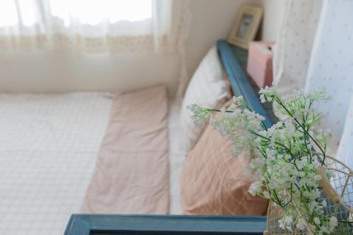 a bedroom with a bed and a vase with a plant at 13 Ohoo in Namhae