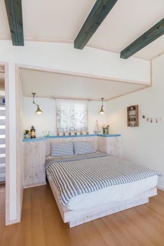 a white bedroom with a large bed in a room at 13 Ohoo in Namhae