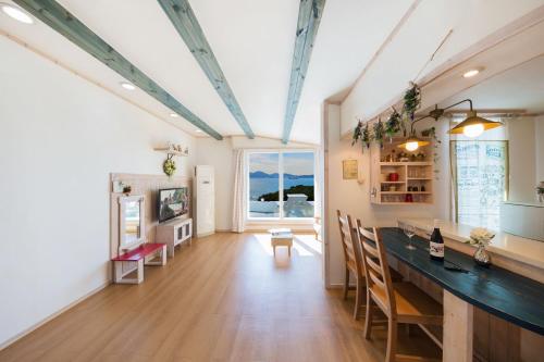 a living room with a table and a dining room at 13 Ohoo in Namhae
