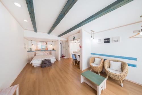 a room with a bed and a desk and chairs at 13 Ohoo in Namhae