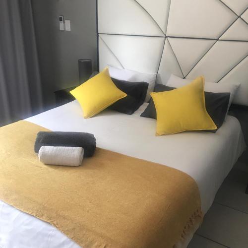 Una cama con almohadas amarillas y negras. en The Empire Court, en Kimberley