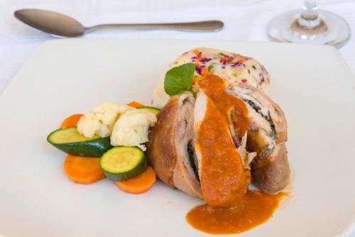 a white plate with a meat with sauce and vegetables at Rainbow Towers Hotel & Conference Centre in Harare