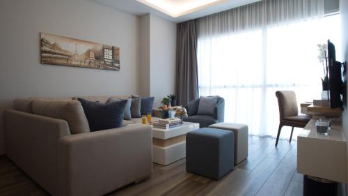 a living room with a couch and chairs and a table at The Stay Furnished Apartments in Dbayeh