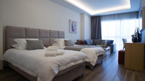 a hotel room with two beds and a couch at The Stay Furnished Apartments in Dbayeh