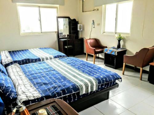 金沙鎮的住宿－祥華酒店，一间卧室配有一张床、两把椅子和窗户