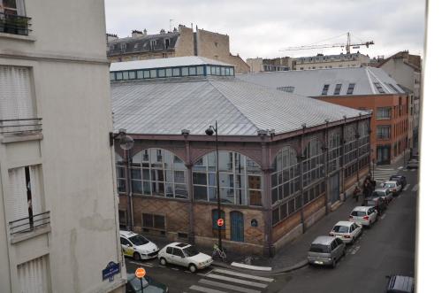 a large building on a city street with parked cars at Hôtel Richard in Paris