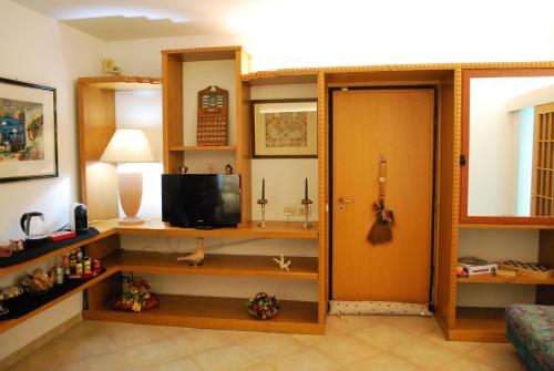 Habitación con sala de estar con TV y puerta. en Etna Hills sea, en Aci Trezza
