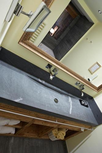 a large mirror above a sink in a room at Hotel Tirol in Ischgl