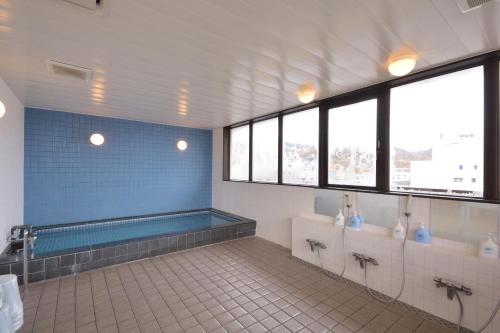 a large bathroom with a tub and two sinks at Daini Prince Hotel Muroran View in Muroran