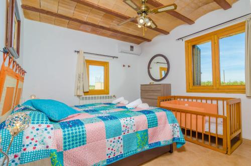 a bedroom with a bed with a crib and a mirror at Son Vanrell in Montuiri