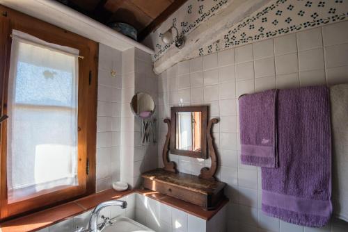 a bathroom with a sink and a mirror and purple towels at Villa Marina in Bosco