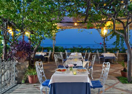a table set up for a dinner party under a pergola at Hotel Pupetto in Positano