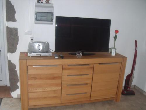 a television on top of a wooden dresser at Casa Bianca in Lajes das Flores