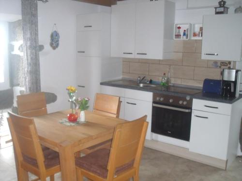 a kitchen with a wooden table and a kitchen with white cabinets at Casa Bianca in Lajes das Flores