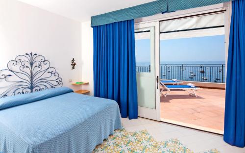 a bedroom with a bed and a sliding glass door at Hotel Pupetto in Positano