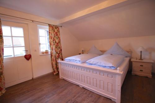 een slaapkamer met een groot wit bed en een raam bij Alpenschloss in Garmisch-Partenkirchen