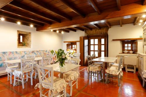 a dining room with white tables and chairs at La Ermita de Deva in Deva