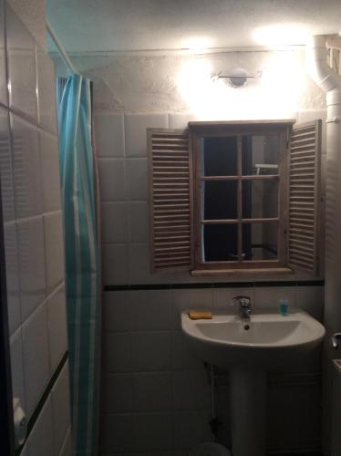 une salle de bain avec un lavabo, un miroir et une fenêtre dans l'établissement Gite Du Montagnol A Payolle, à Sainte-Marie-de-Campan