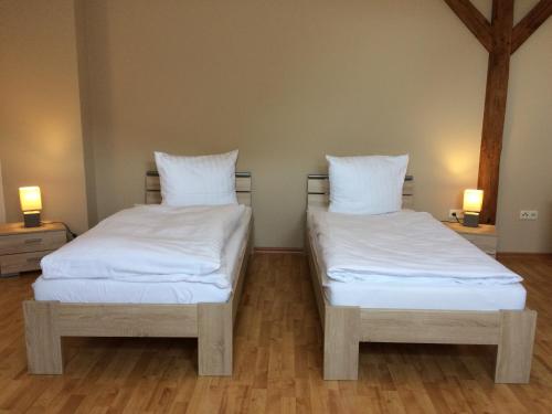 2 camas en una habitación con sábanas y almohadas blancas en Gasthof Pritzier, en Pritzier