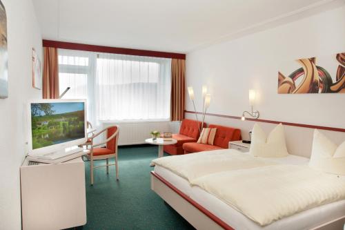 a hotel room with a bed and a living room at Hessen Hotelpark Hohenroda in Hohenroda