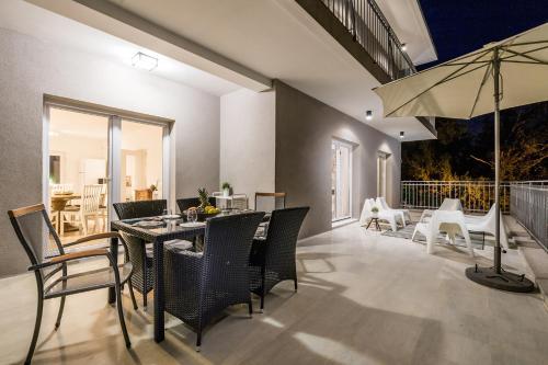 a dining room with a table and chairs and an umbrella at Villa Lovran, heated pool and Spa in Lovran