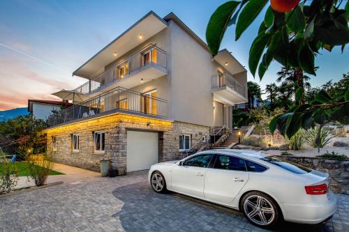 um carro branco estacionado em frente a uma casa em Villa Lovran, heated pool and Spa em Lovran
