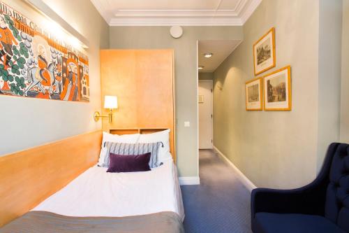 a bedroom with a large bed and a chair at Lady Hamilton Hotel in Stockholm
