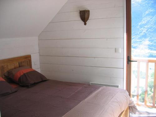CamparanにあるLes GITES DE CAMPARAN - gîte "la BERGERIE AVEC SPA"の窓付きの部屋にベッド付きのベッドルーム1室があります。