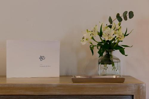 a vase of white flowers on a wooden table at La Ermita de Deva in Deva