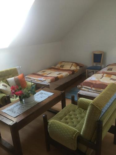 een kamer met drie bedden en een tafel en stoelen bij Objekt Nizna in Nižná