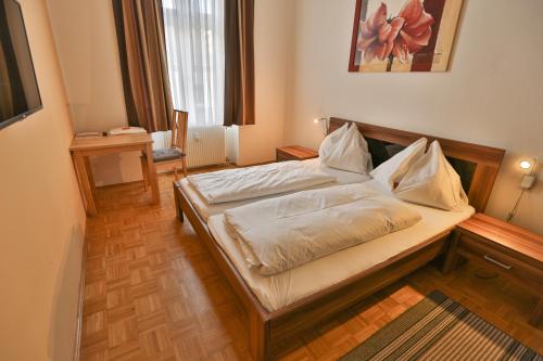 a bedroom with a bed with white sheets on it at Feldkirchnerhof in Feldkirchen bei Graz