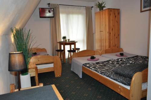 pokój hotelowy z 2 łóżkami, stołem i krzesłami w obiekcie Willa Otulina pod Giewontem w Zakopanem