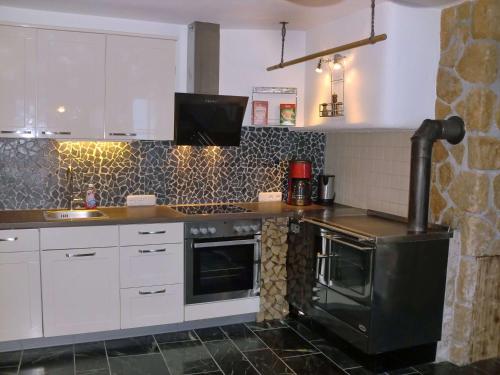 a kitchen with a black stove and white cabinets at Almliesl RAUR-521 in Rauris