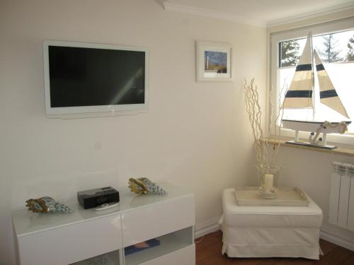een woonkamer met een flatscreen-tv aan de muur bij Exklusiv Wohnung Nika in Westerland