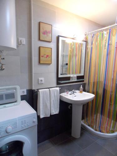 a bathroom with a sink and a shower curtain at Apartamentos Capuchinas in Plasencia