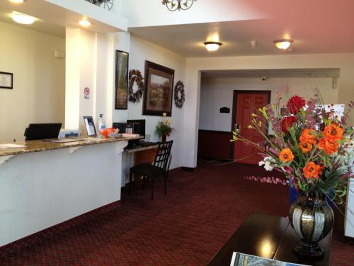 a lobby with a counter with a vase of flowers at Howard Johnson by Wyndham Lubbock TX in Lubbock