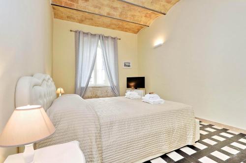 a bedroom with a white bed and a window at Colosseum Suite in Rome