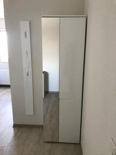 a tall white door in a room with a mirror at Pension Stamperl Bar in Vohburg an der Donau