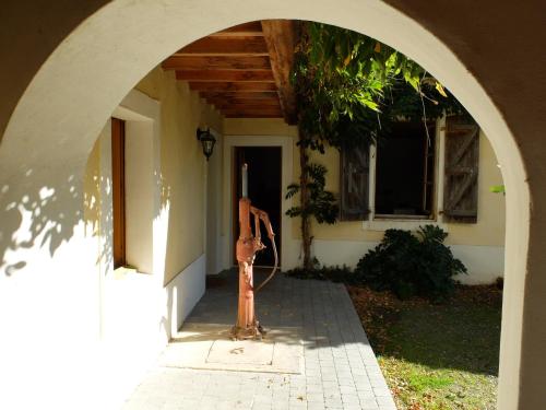 an archway with a fire hydrant in front of a house at De l'Autre Côté in Garlin
