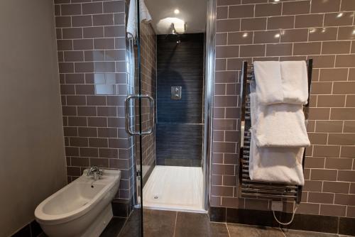 a bathroom with a shower and a toilet and a sink at The Colonnade in London