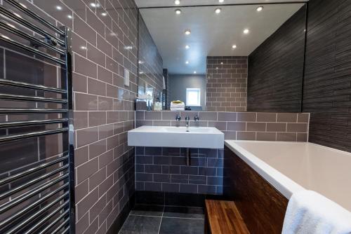 a bathroom with a sink, toilet, and bathtub at The Colonnade in London