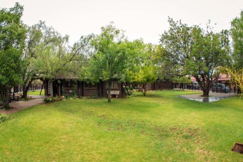 a yard with a building with trees and grass at Horseshoe Inn and Conference Center in Kimberley