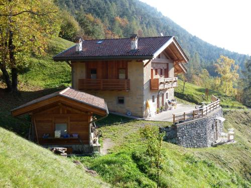 a small wooden house on a hill in a field at agriturismo la Meta in Pieve di Bono