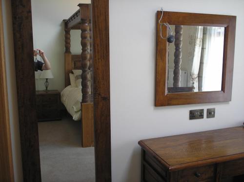 a person taking a picture of a bedroom with a mirror at Green Grove Country House in Malham