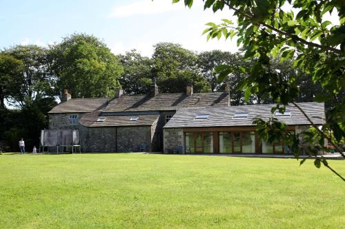 an old stone house with a green lawn at Green Grove Country House in Malham