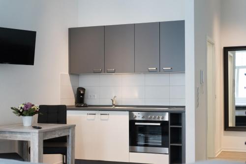 a kitchen with black and white cabinets and a table at Appartement am Schloss in Gießen