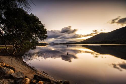 a view of a lake with the sun setting at Diamond Waters Caravan Park in Dunbogan