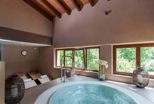 bañera grande en una habitación con ventanas en Molino de Alcuneza Relais & Châteaux, en Sigüenza